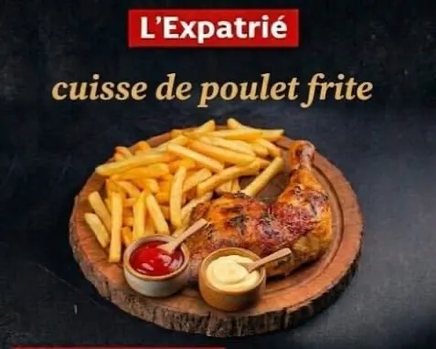 Cuisse de poulet rôtie et frites dorées sur une planche en bois, avec deux ramequins de ketchup et de mayonnaise.